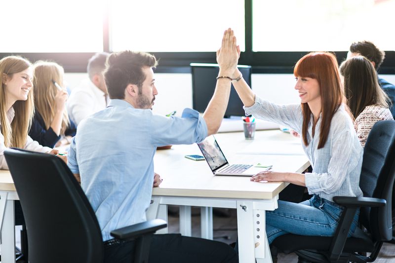 Friends Exchanging the Highfive in the Office