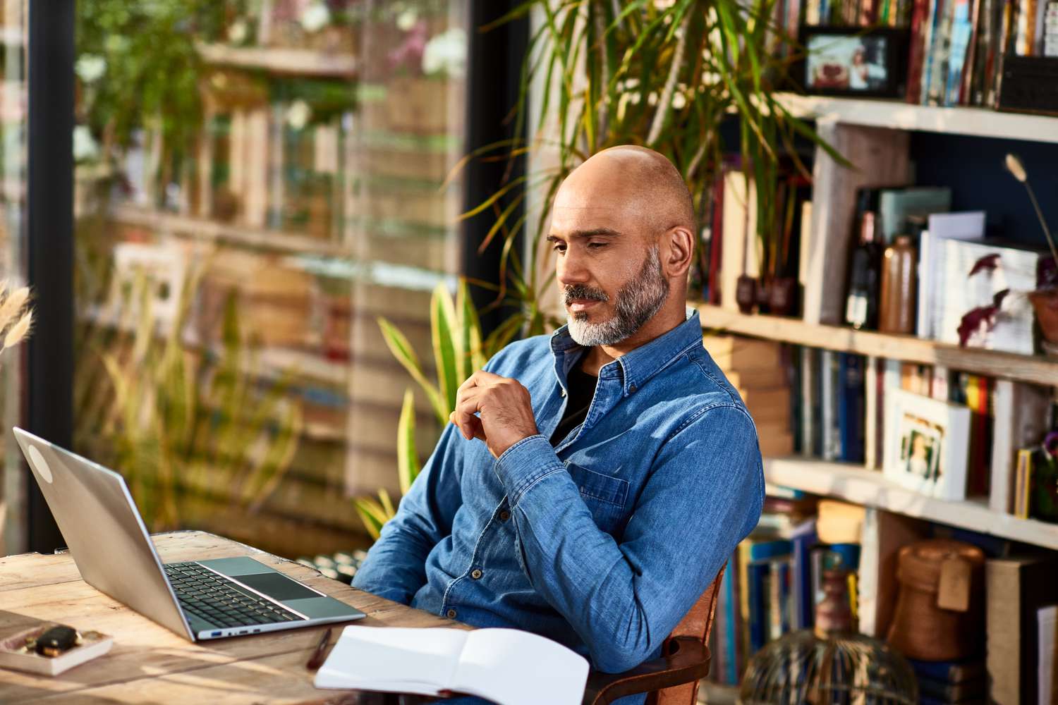 A man sits at a desk with a laptop
