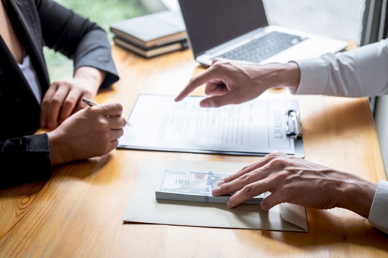 Cropped Hands of Businessman Bribing Female Coworker Signing Contract in Office