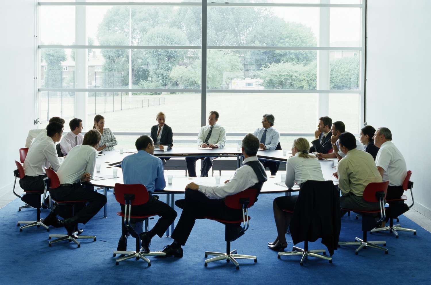 Businessmen and women in meeting at large circular table