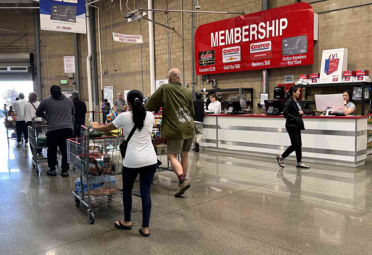 Several customers with shopping carts in a Costco