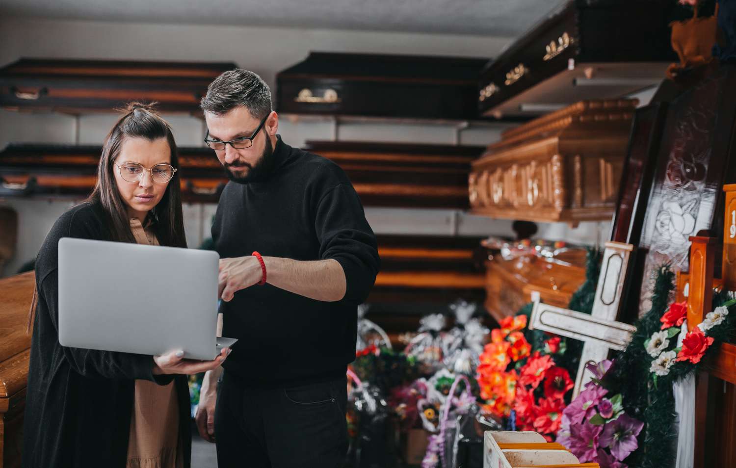 Funeral home workers at a funeral home looking on a computer