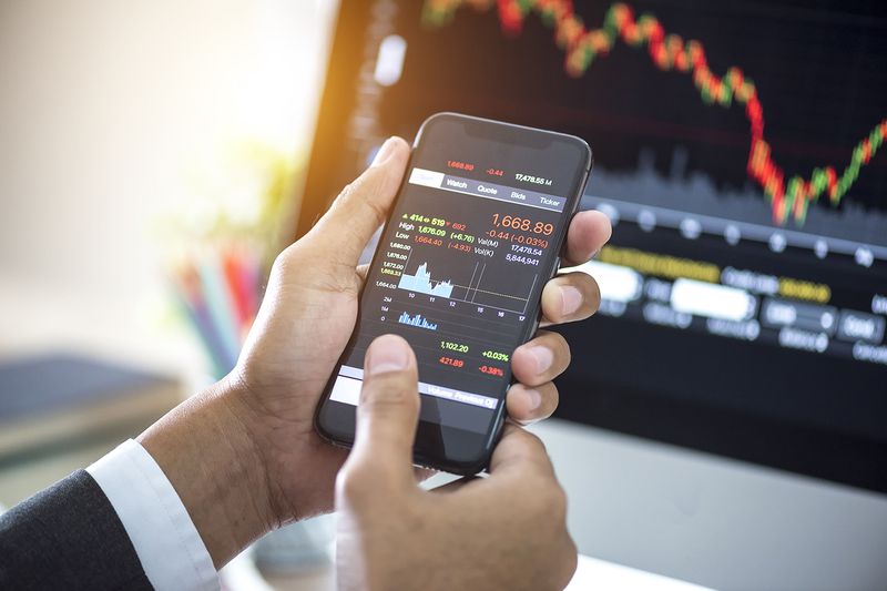 Investor Analyzing Stock Market Investments With Financial Dashboard on Smartphone and Computer Screens