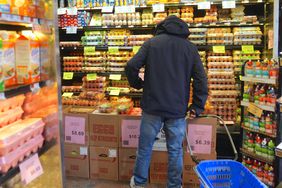 A customer is seen during shopping at a supermarket as packages of eggs are seen on the shelves of the egg aisle in New York City
