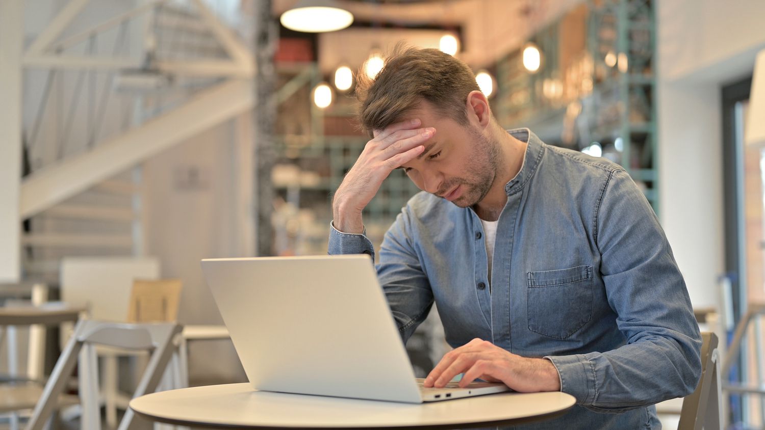 A man with a computer in a cafe