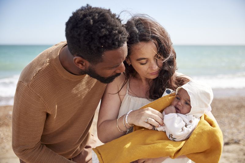 Mother and father with young baby at the beach