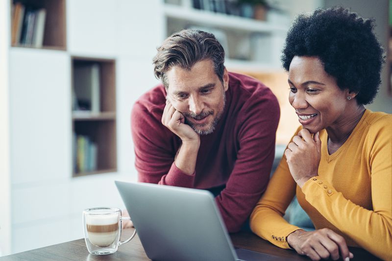 A mature couple looks at a laptop together. 