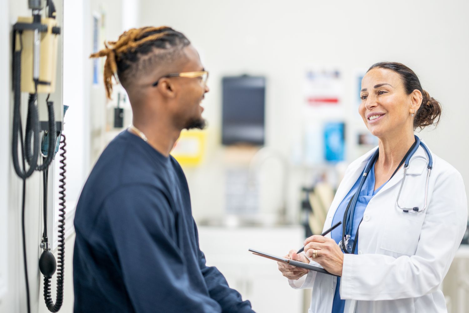 Patient talking with doctor about the procedures covered by health insurance premiums.