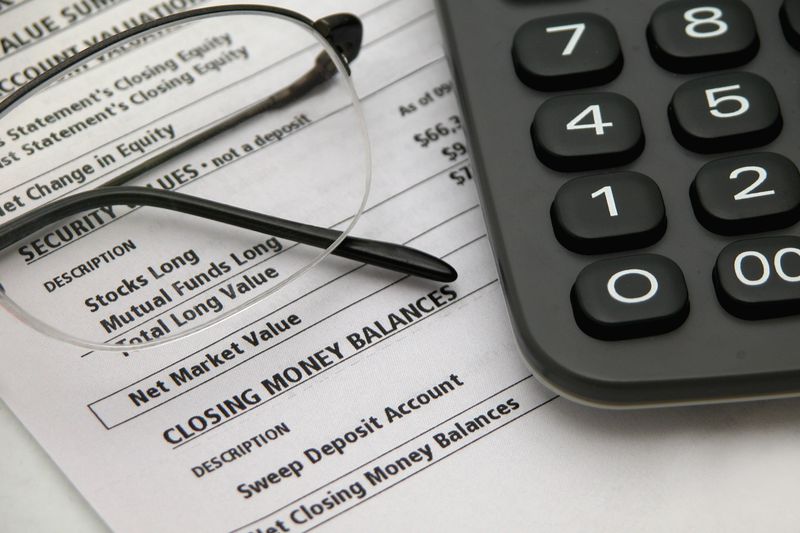 A financial statement with glasses and calculator on the desk.