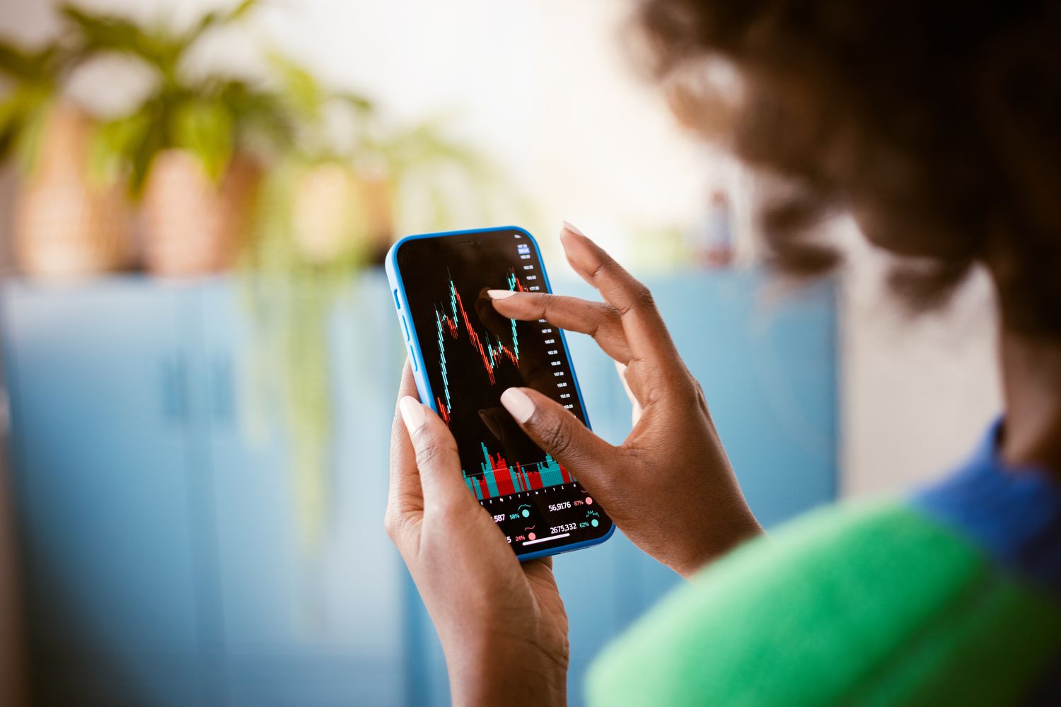 An investor uses a smart phone to monitor the performance of an investment during the trading day.