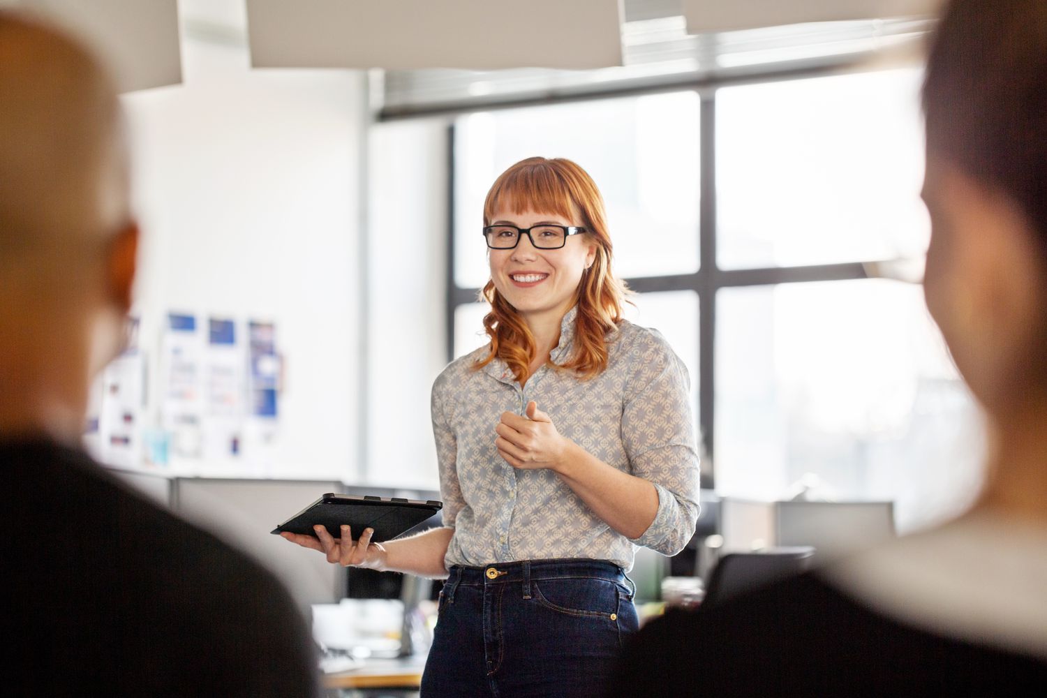 Young woman leading a meeting holding a tablet