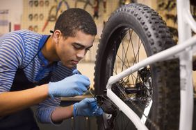 Young mechanic fixing some gears on a bike