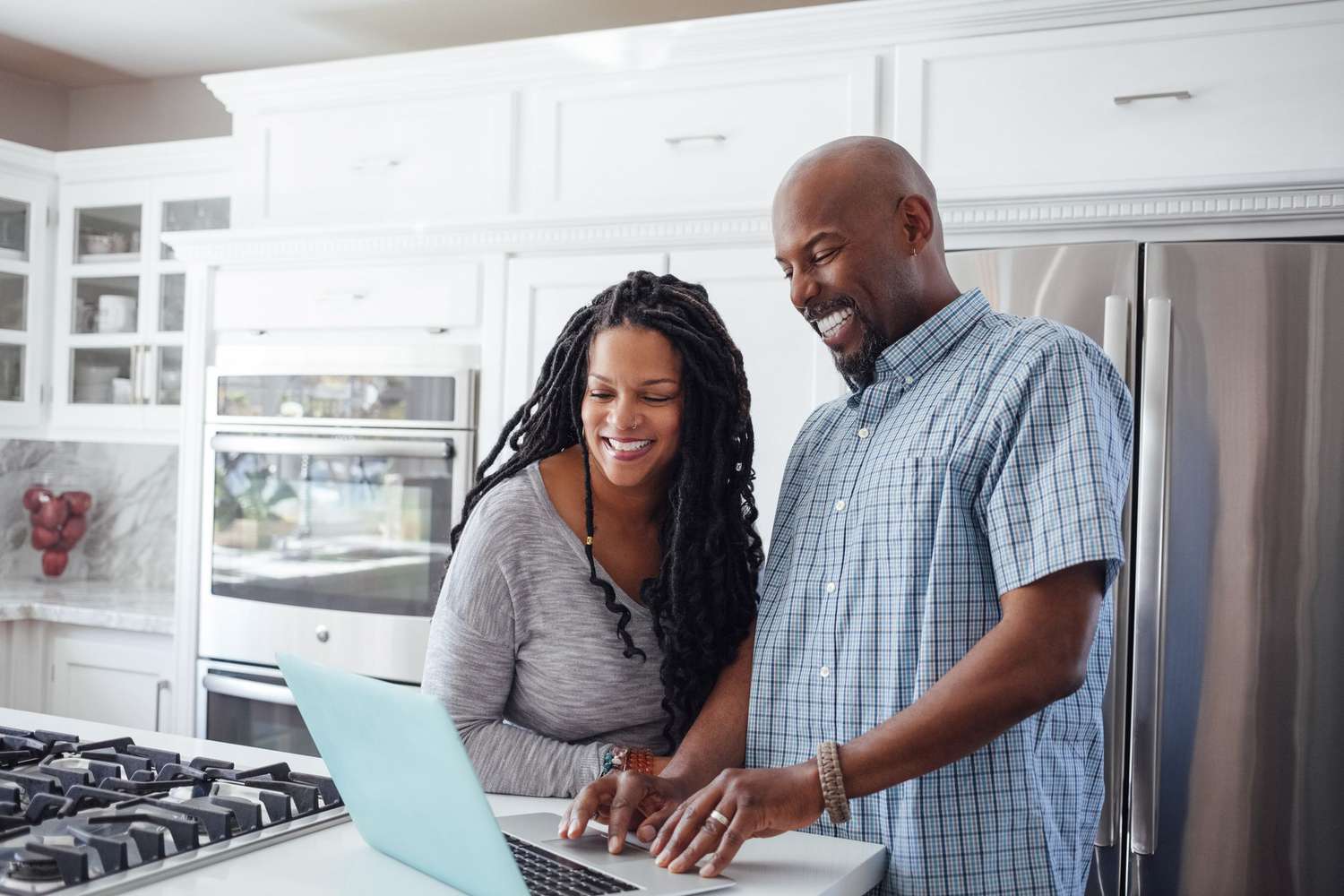 A couple working on a laptop in their kitchen