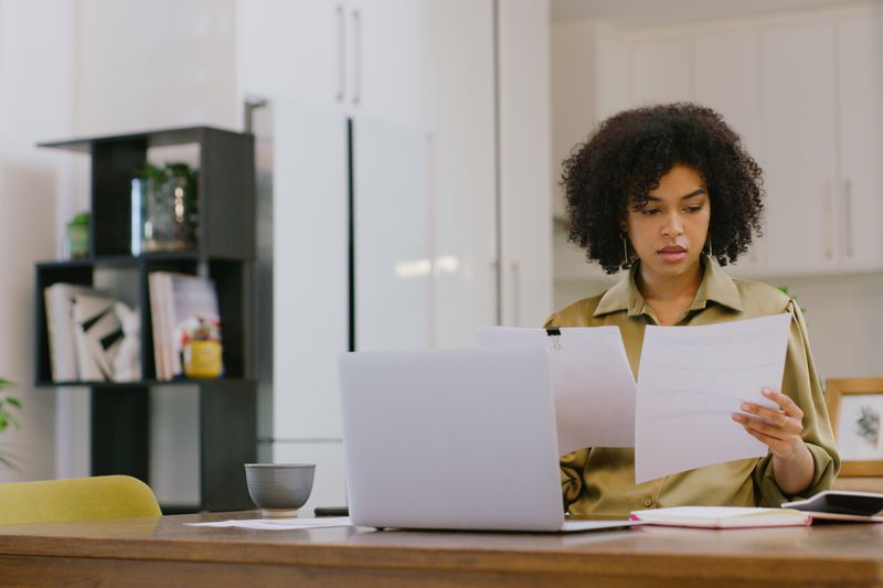 A woman reviews two documents.