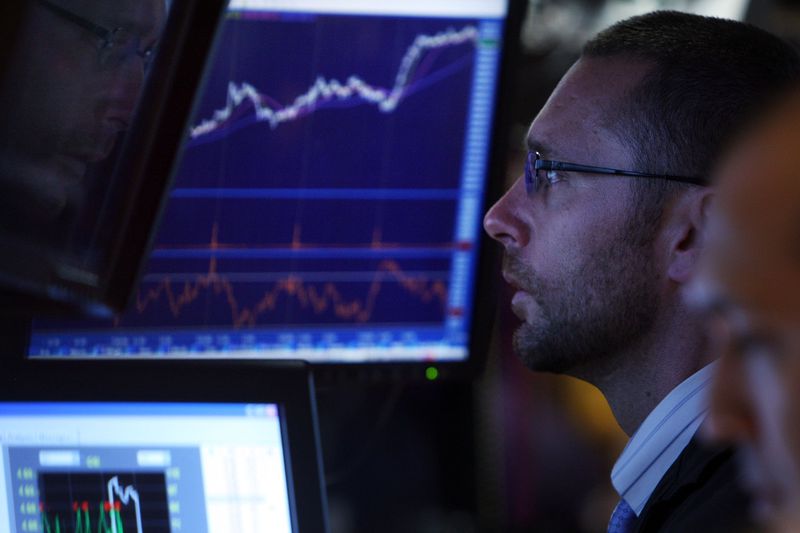 A stock trader on the floor of the New York Stock Exchange looking at various trades being executed.
