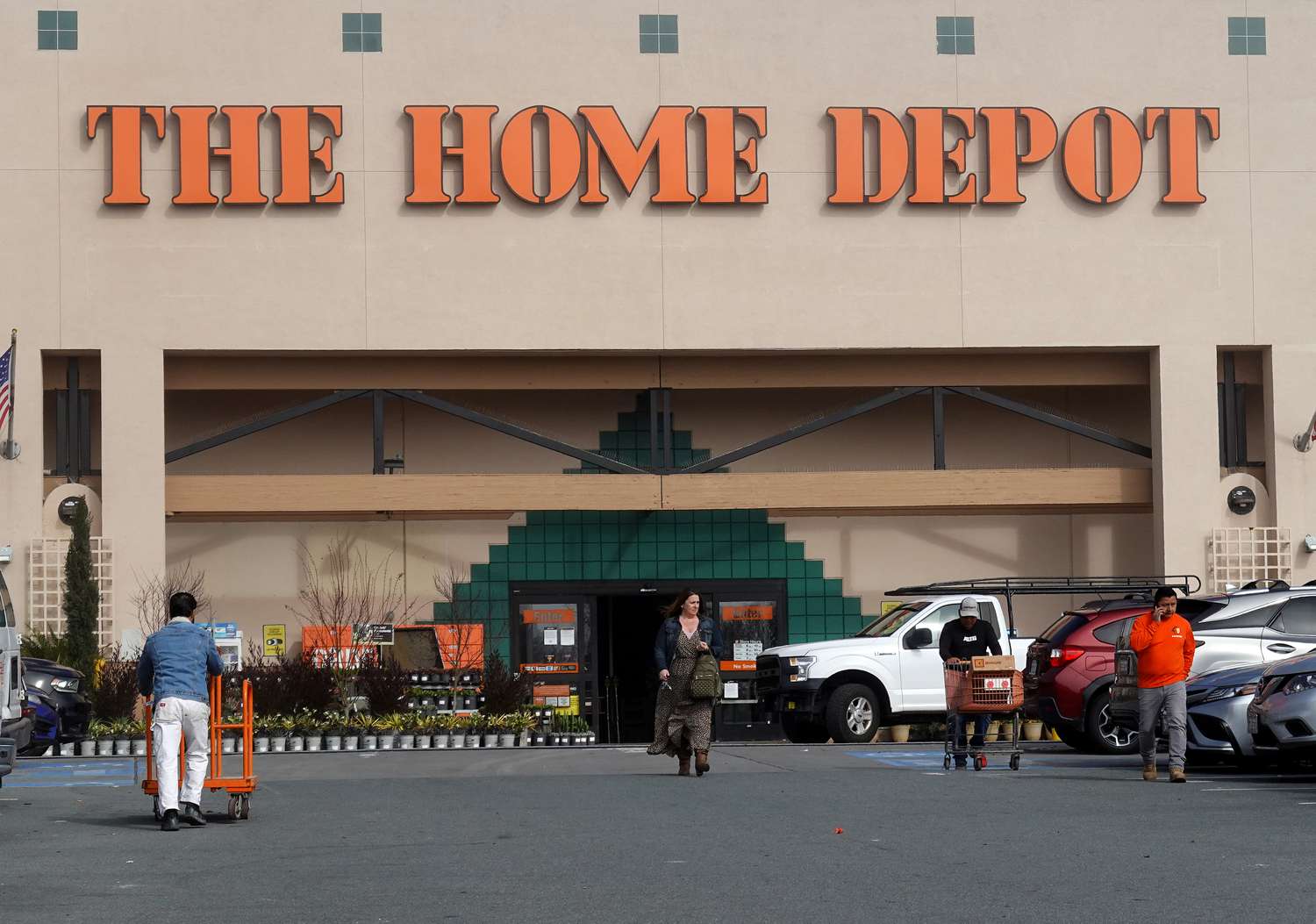 People and cars are seen in front of a Home Depot store.