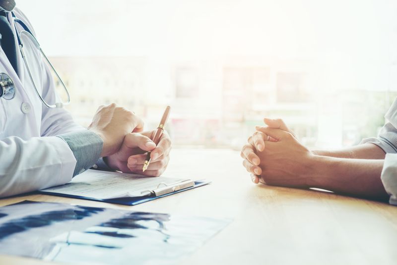 Medical proxy and doctor sit across a desk to review difficult choices