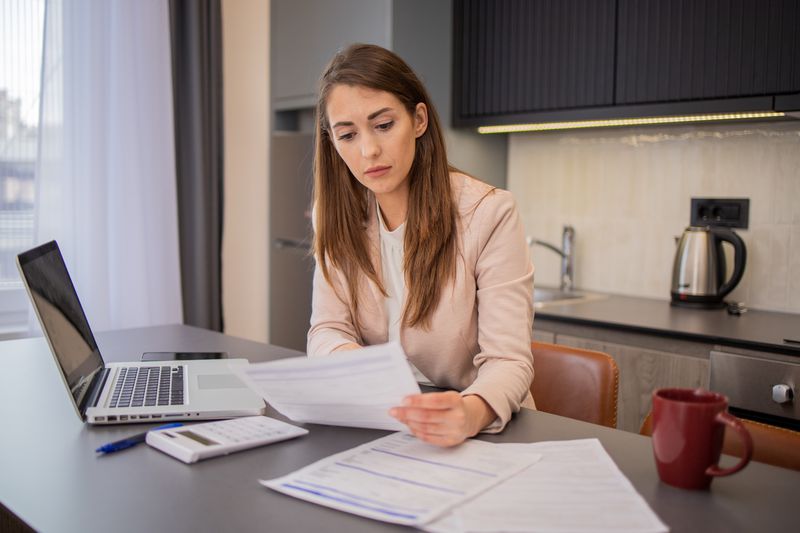 A woman with papers and a computer