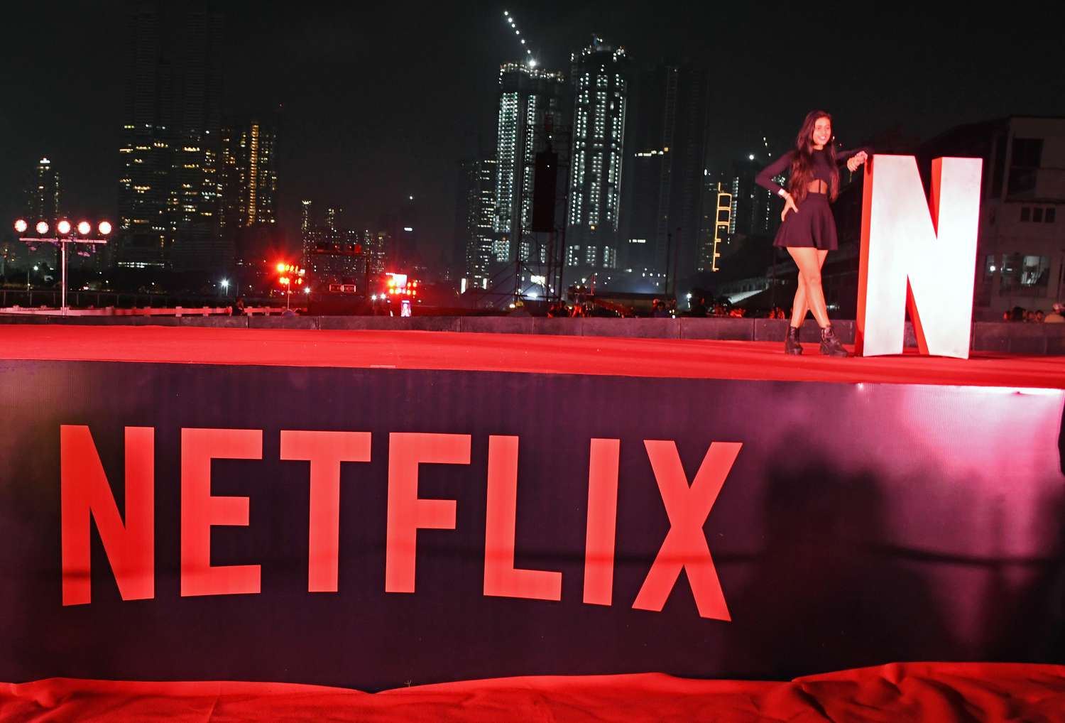 A woman poses for a photo near Netflix logo at a promotional event for the Netflix television series 'Heeramandi : The Diamond Bazaar' in Mumbai.