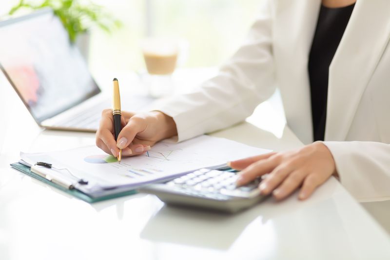Hands of businessman working with business document and laptop on the table.