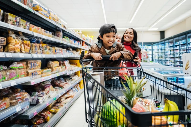 Family at grocery store with young boy pushing the cart.