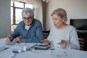 Couple discussing finances with a calculator