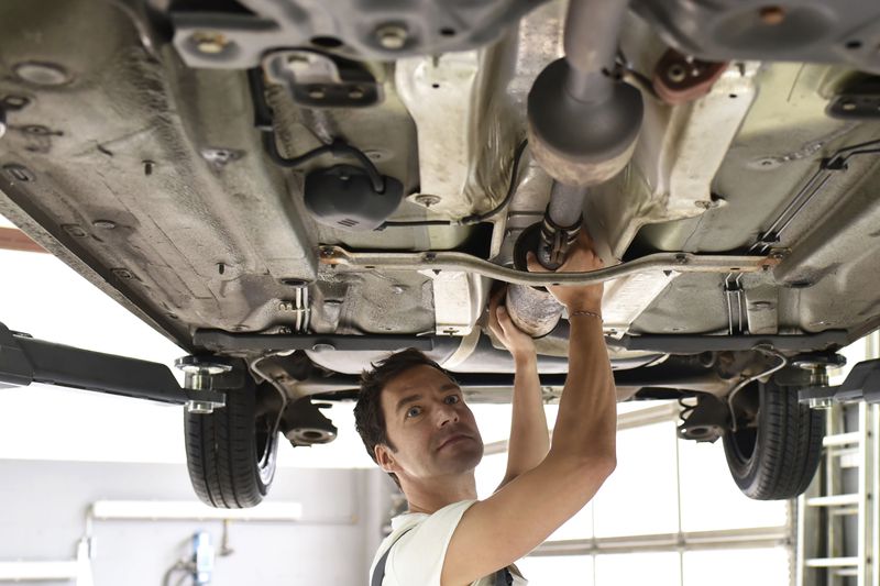 technician inspecting catalytic converter