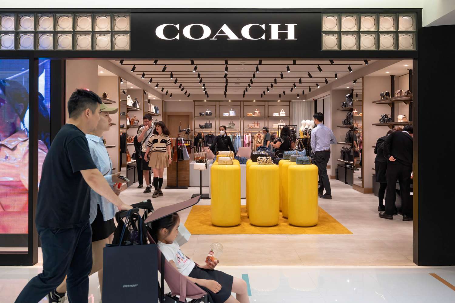 Shoppers approach a Coach store.