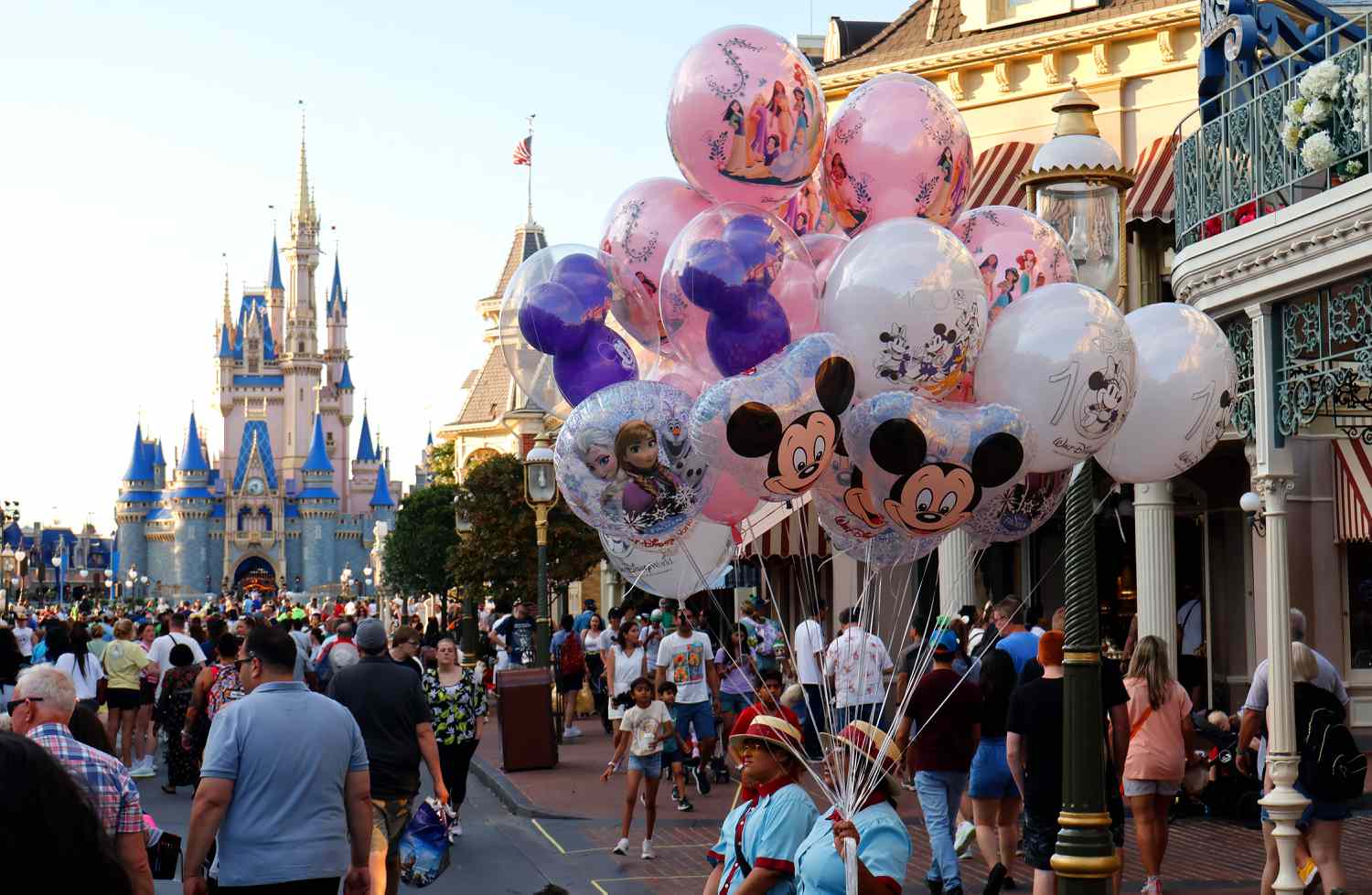 A vendor sells balloons along Main Street in front of Cinderella's Castle as the sun sets at the Magic Kingdom Park at Walt Disney World.