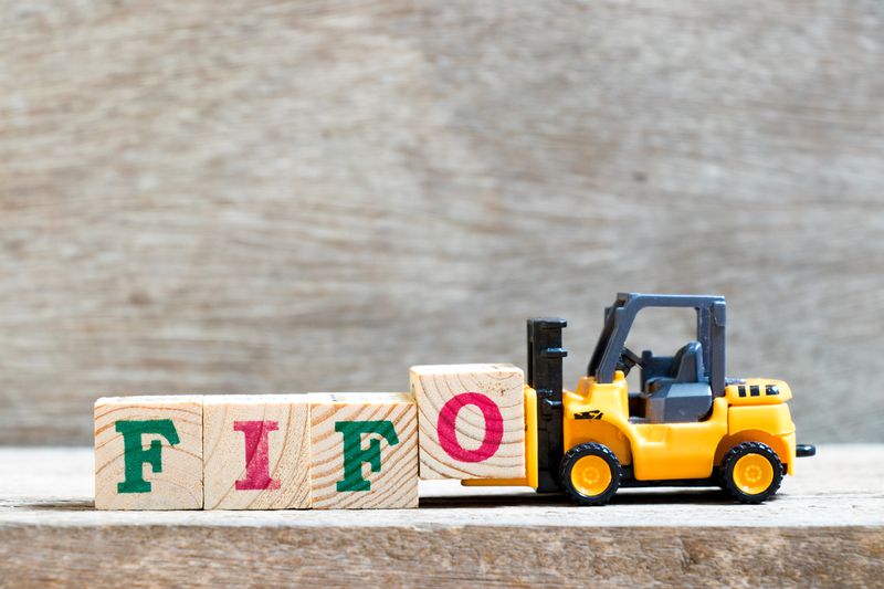 Toy forklift hold letter blocks reading FIFO