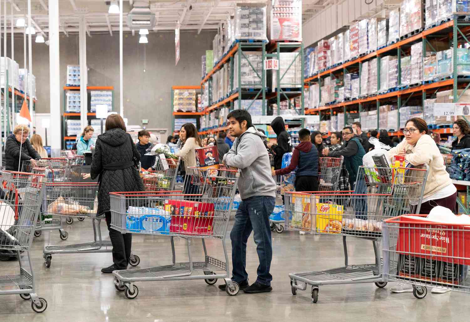 A line of customers with shopping carts waits to check out at a supermarket in California.