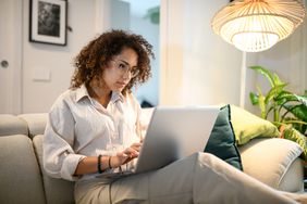 Woman using laptop computer on a couch