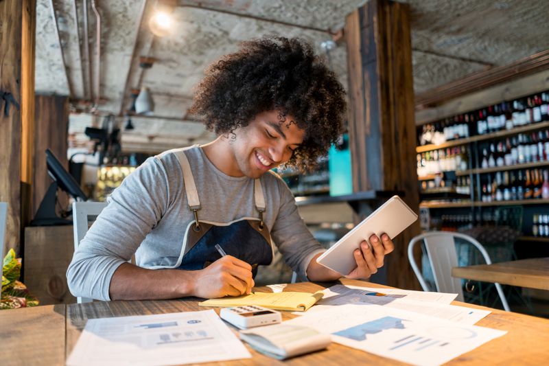 Business owner smiling and bookkeeping at a restaurant