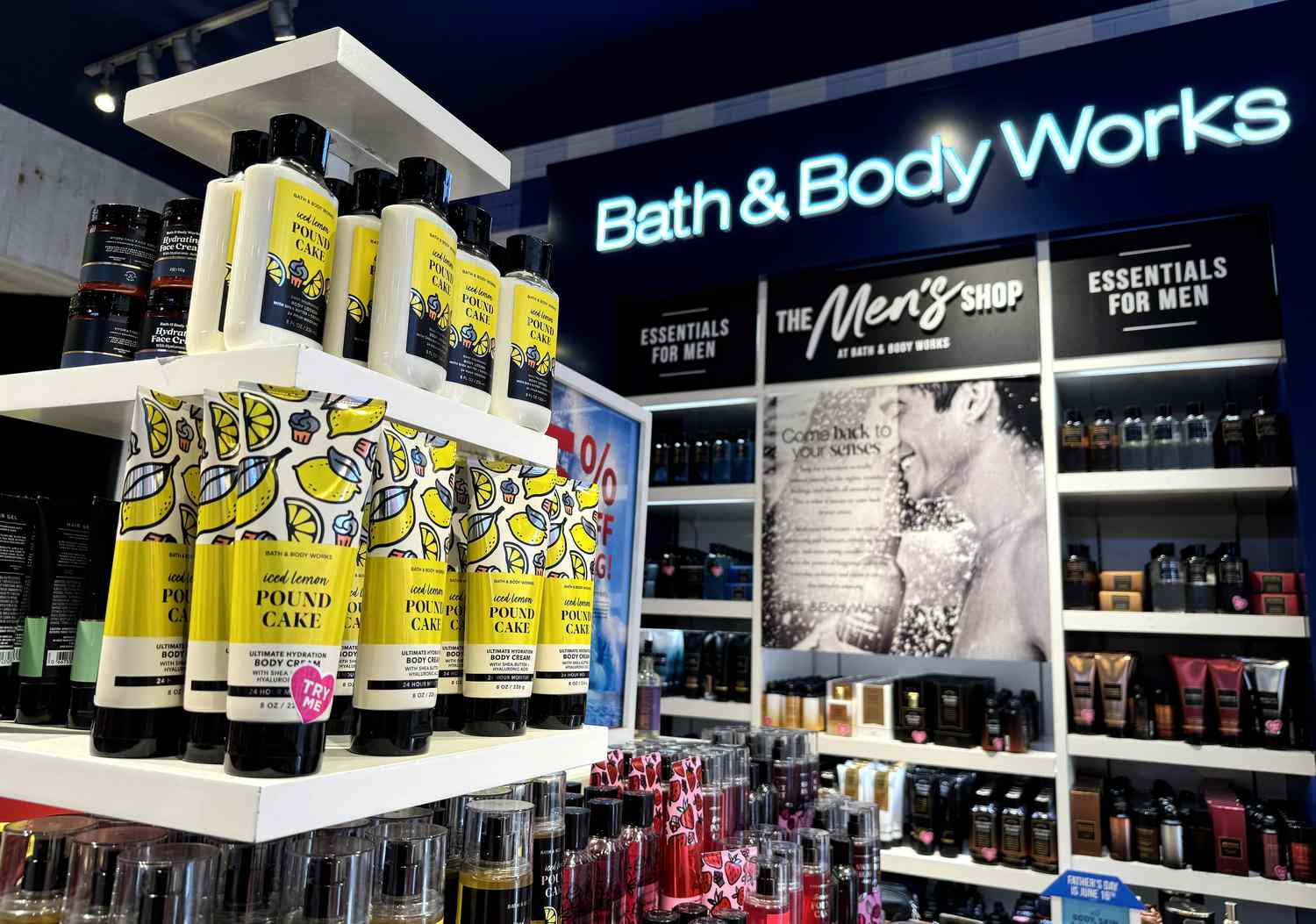 Bath & Body Works products on shelves in a store with the company's logo on the wall