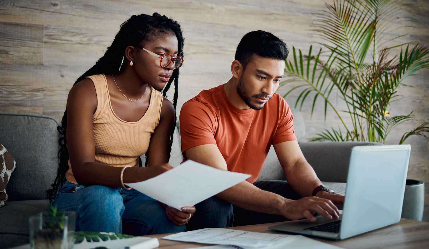 A couple reviews paperwork and works on a laptop.