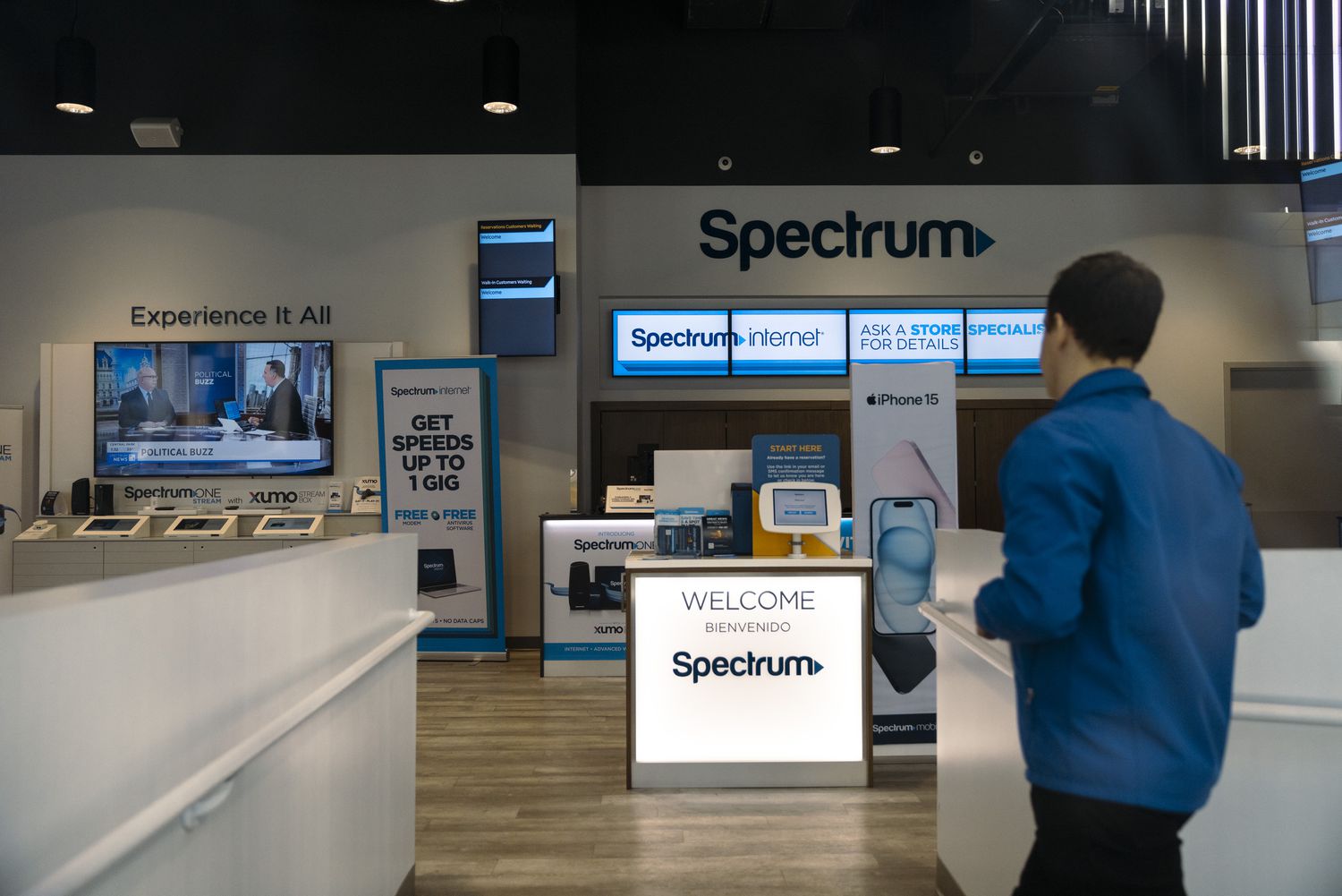 A person walks inside of a Spectrum store, with the company logo and products inside the store