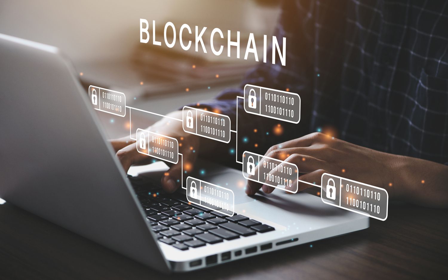 A person typing at a laptop with illustrations of the blockchain floating over the keyboard.