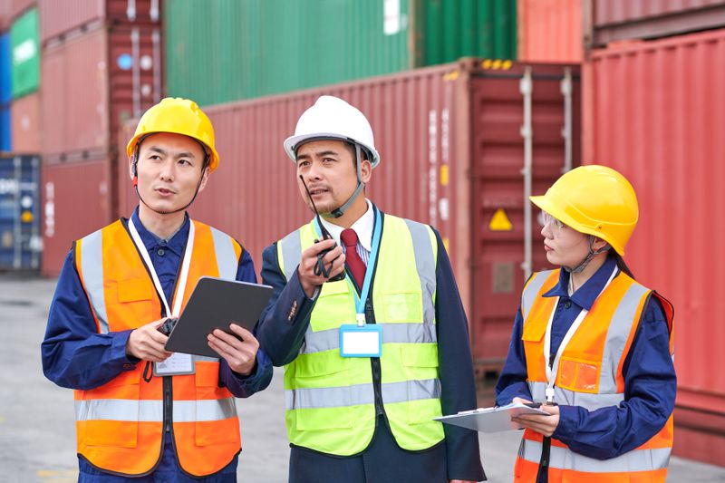 Three dock workers discussing at a commercial dock