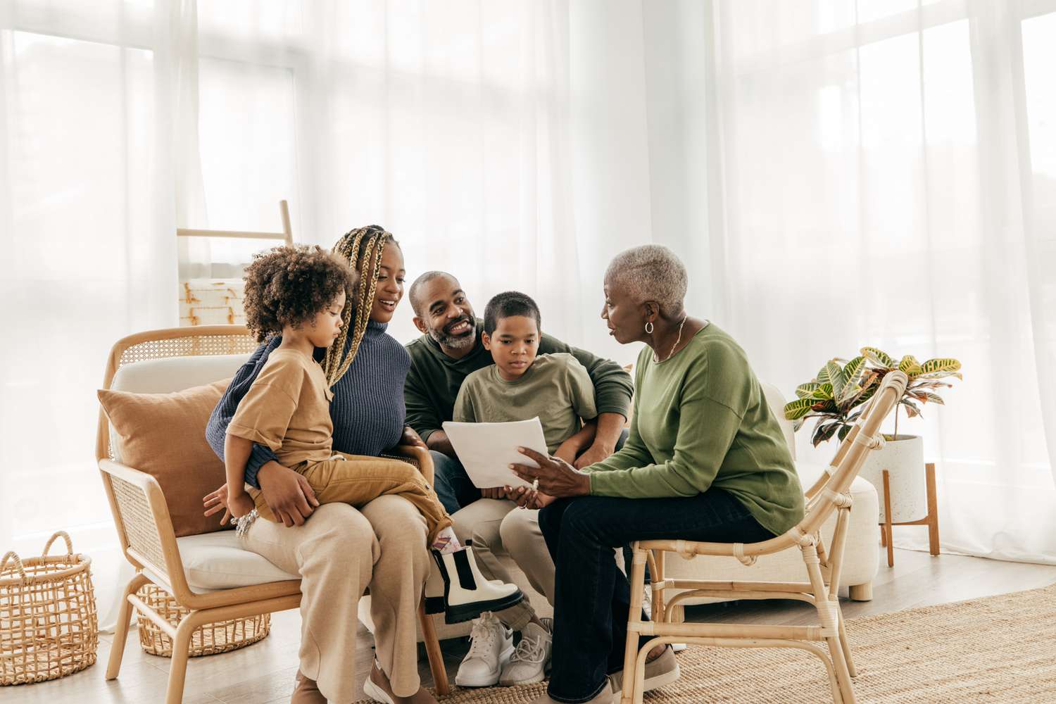 Mother, father, and children discuss financial planning with grandmother. 
