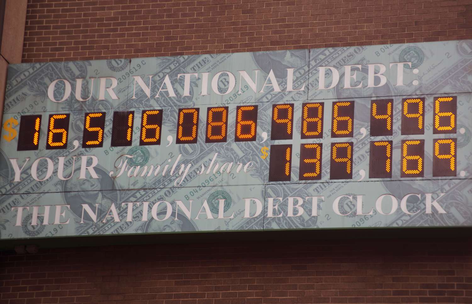A digital national debt clock display board shows a string of digits below the words "Our National Debt".