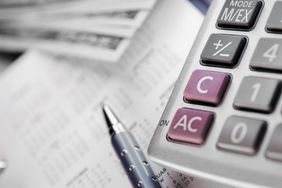 Close-up of a calculator and a pen on a calendar