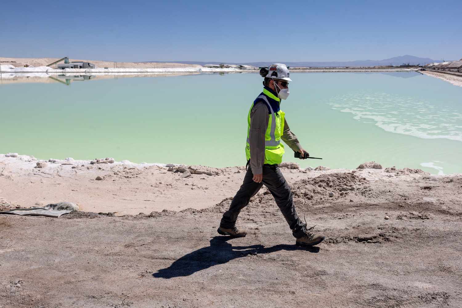 A lithium mine supervisor inspects an evaporation pond of lithium-rich brine in the Atacama Desert on August 24, 2022
