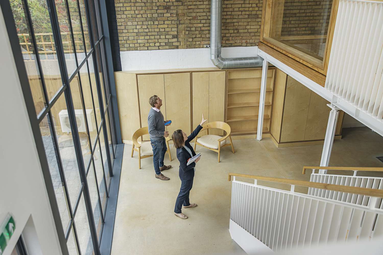 A real estate agent shows a client around a commercial office space. 