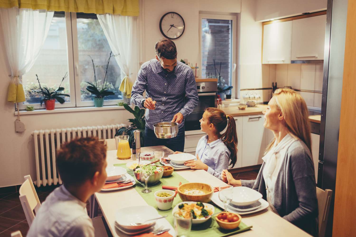 A family of four eating dinner at home