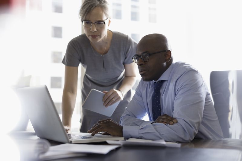 Two colleagues working together on a computer.