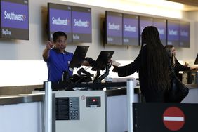 A Southwest Airlines ticketing agent helps customers at San Francisco International Airport on April 24, 2025 in San Bruno, California.