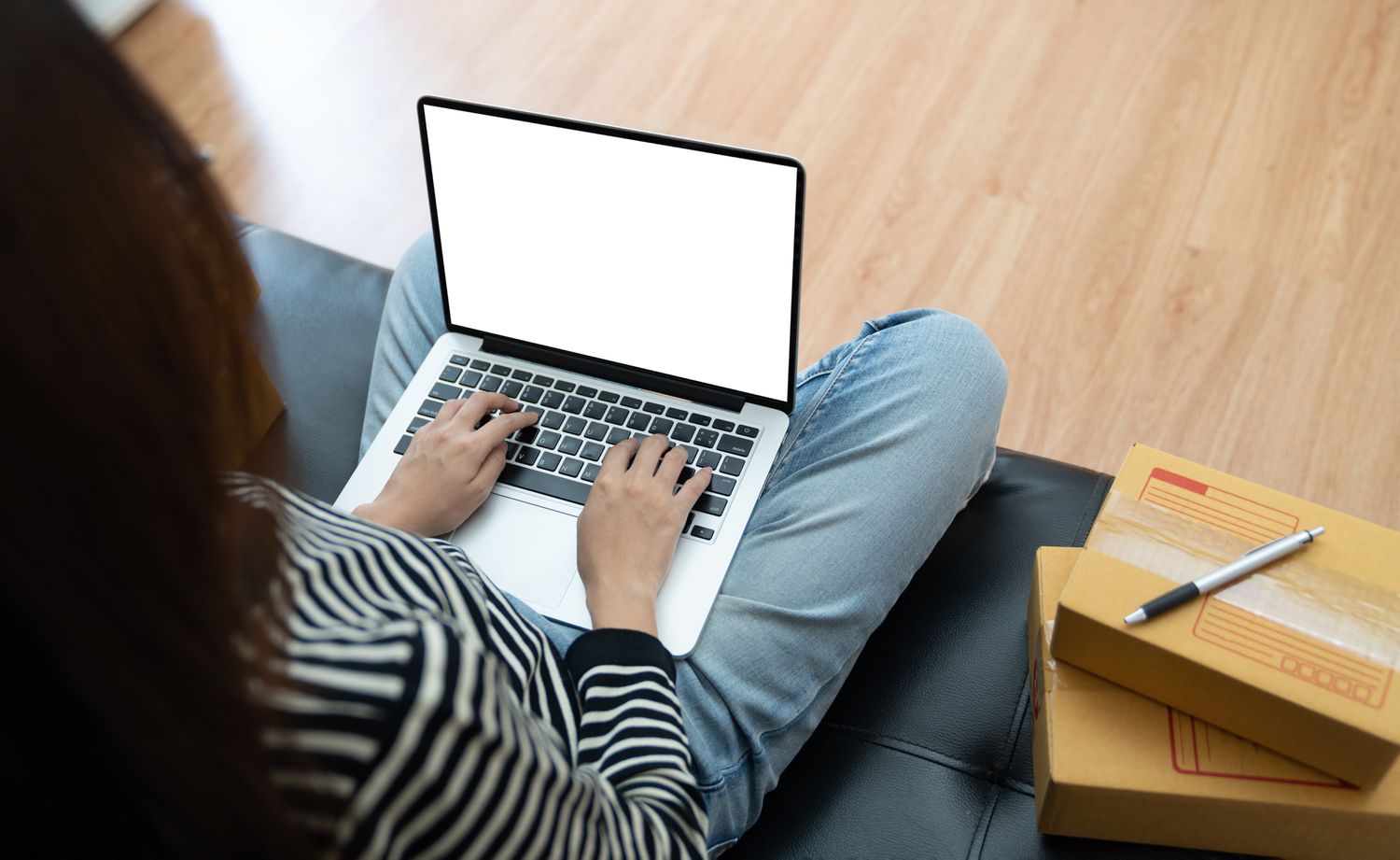 Woman sitting cross legged with her open laptop on her lap
