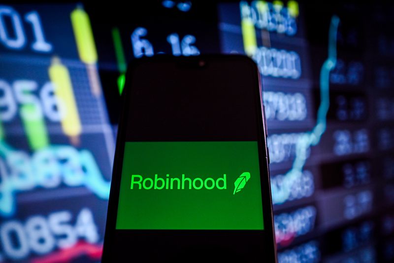 A RobinHood logo is displayed on a smartphone with stock market percentages on the background