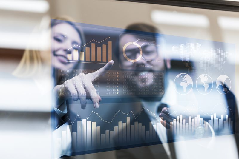 Two people looking at graphs and unmarked numbers