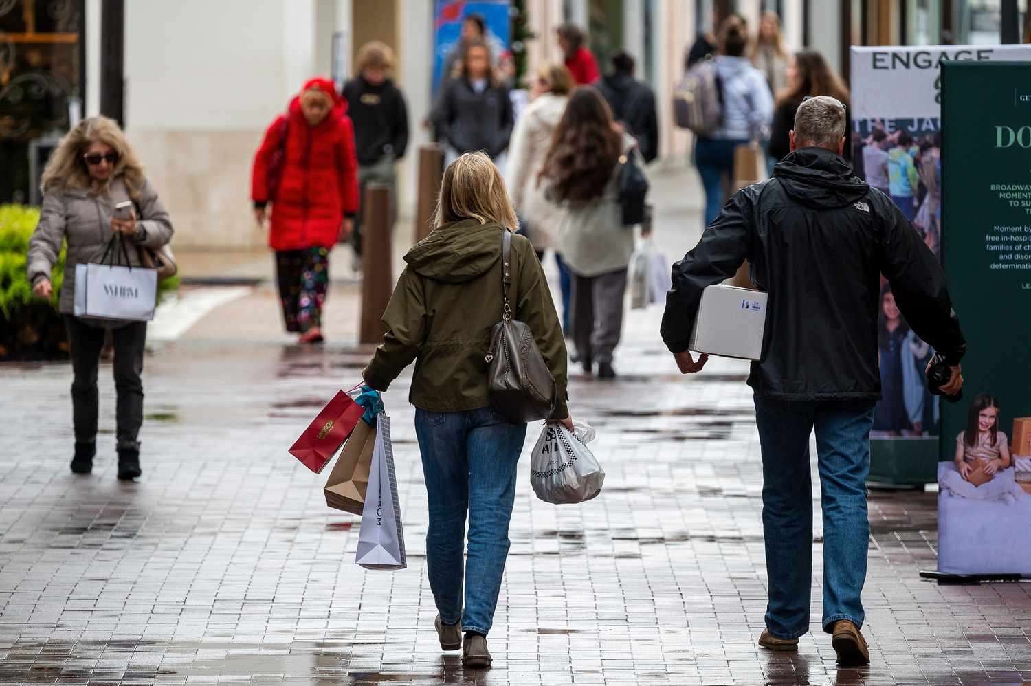 People carry shopping bags. 